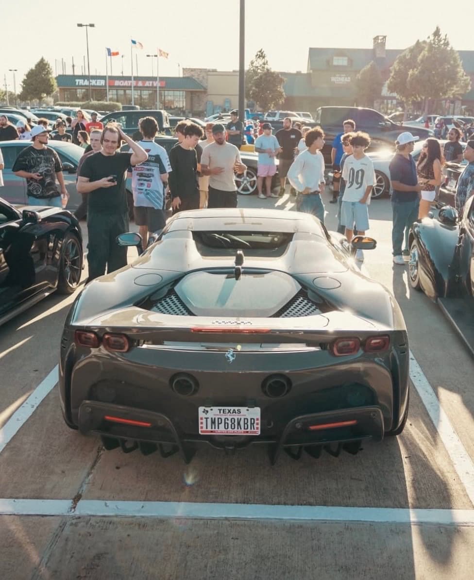 Gray Ferrari SF90 shown rear-on with spectators gathered around it