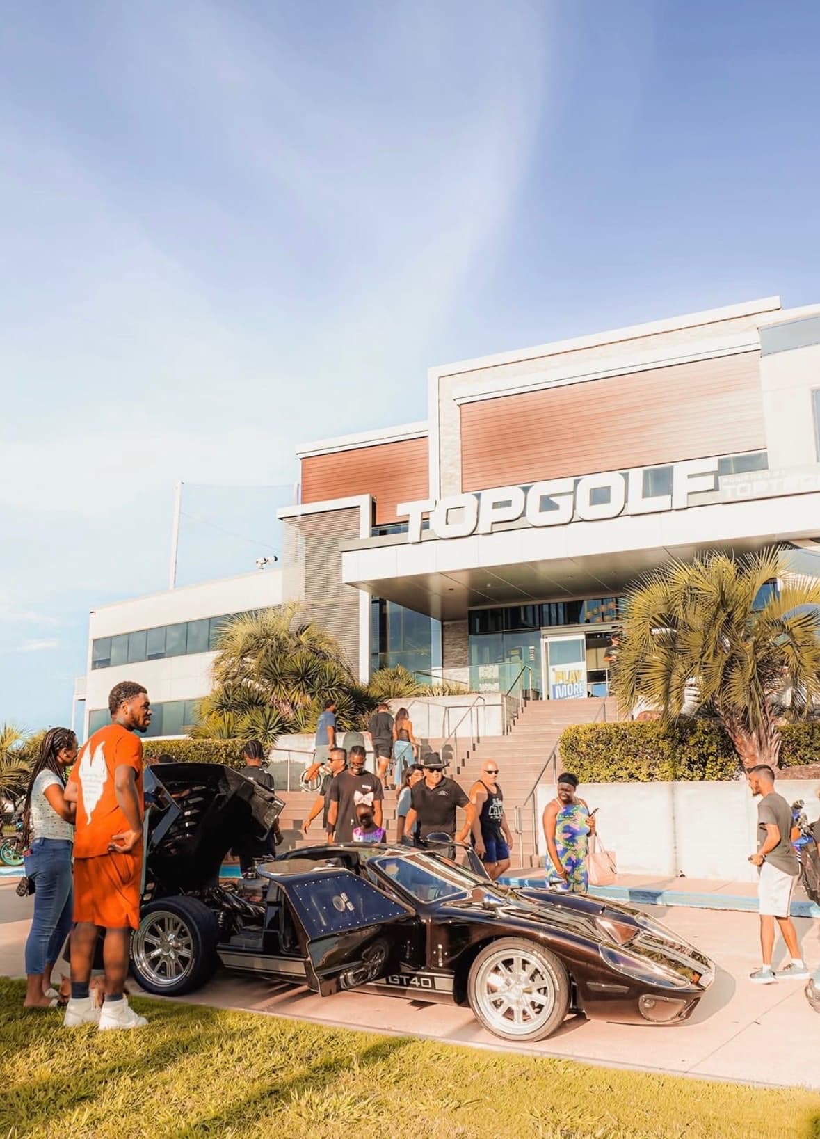 Black Ford GT40 parked on the grass in front of Topgolf
