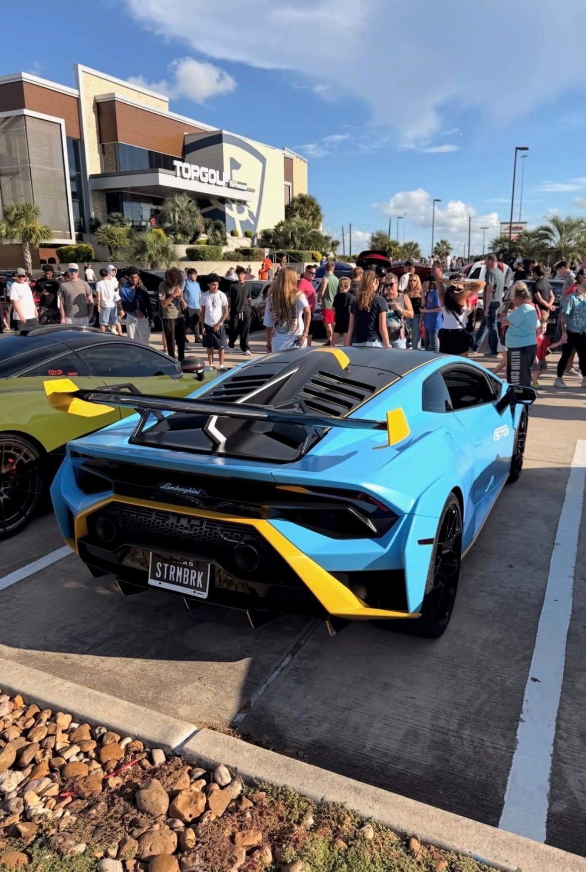 Blue and yellow Lamborghini Huracán STO shown from the rear at the meet