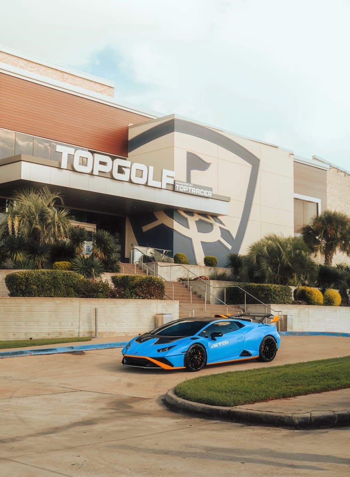 Blue Lamborghini Huracán STO parked in front of the Topgolf entrance