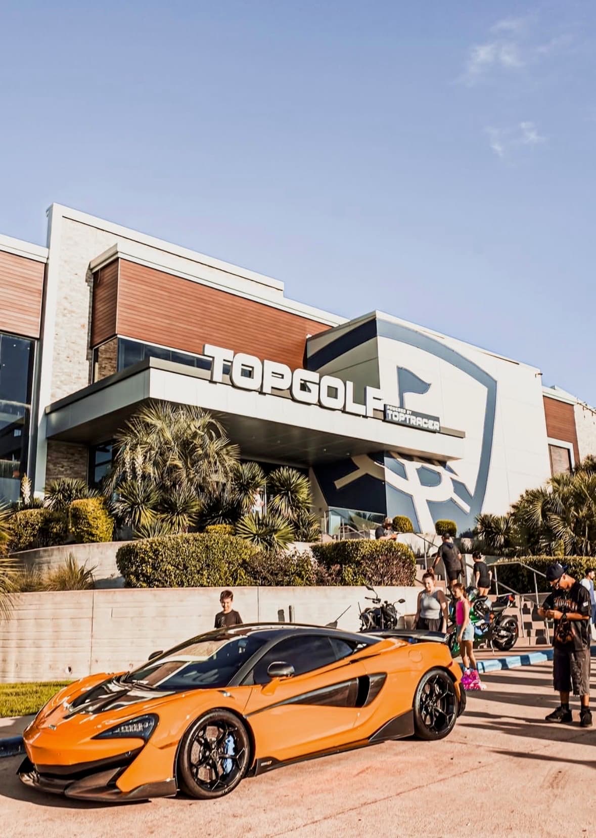 Orange McLaren parked outside Topgolf at a BL4NK event