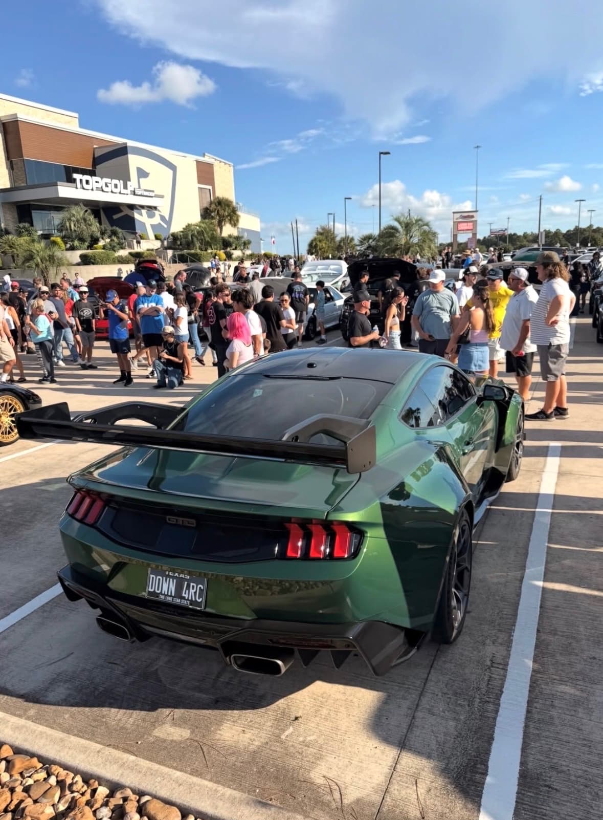 Green Ford Mustang GTD with a tall wing parked at the meet